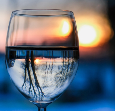 acqua depurata da pfas e agenti inquinanti dentro un bicchiere con natura riflessa nel vetro